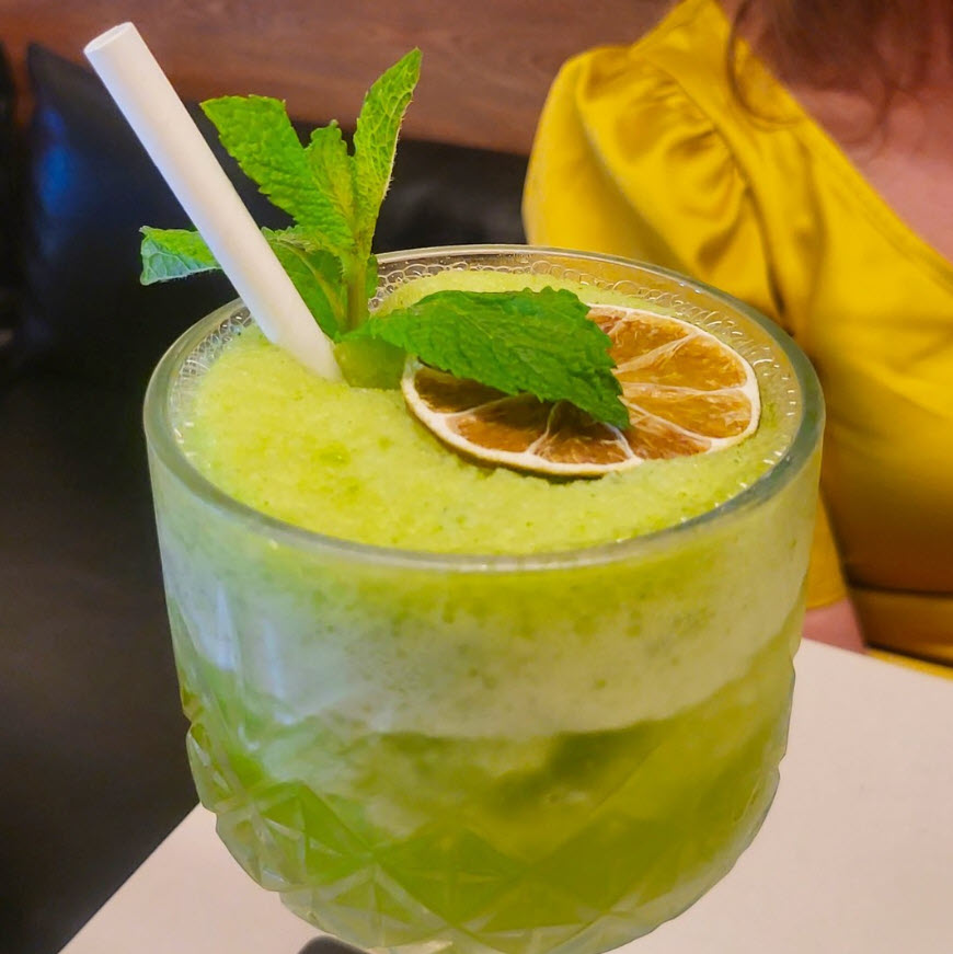 Tropical green cocktail drink with mint on top.