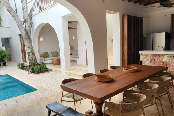 Casa Perla. Open Kitchen with long wooden table facing onto the outside pool