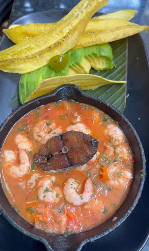 A vibrant shrimp stew served in a rustic bowl with rice and plantains at La Mulata in Cartagena.