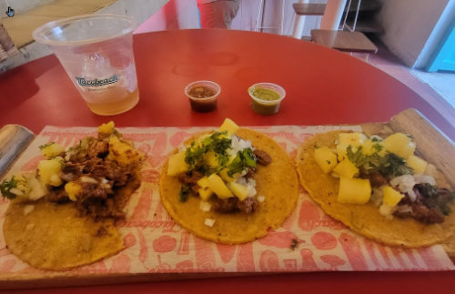 A vibrant trio of tacos paired with a glass of tequila at TacoBeach in Cartagena, Colombia.